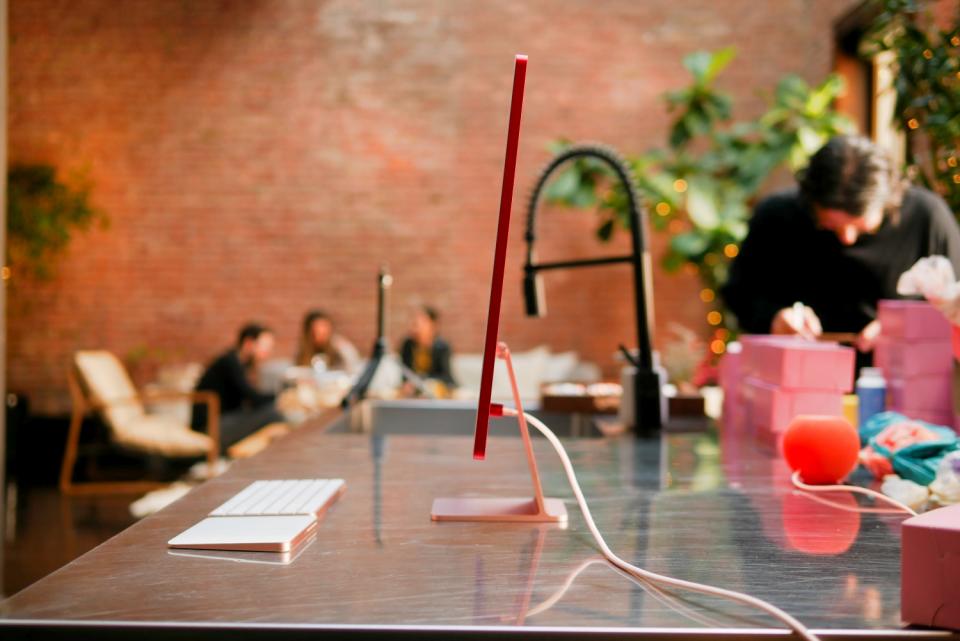 Side view of Apple iMac 24-inch in red on top of island table