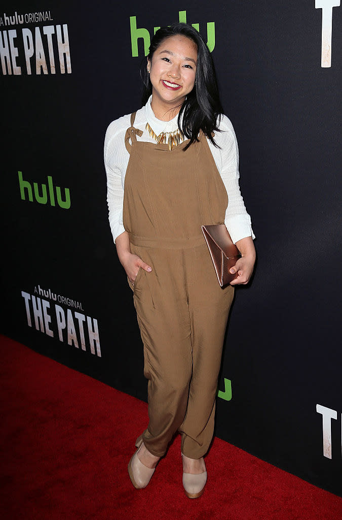 Stephanie smiling on the red carpet in overalls