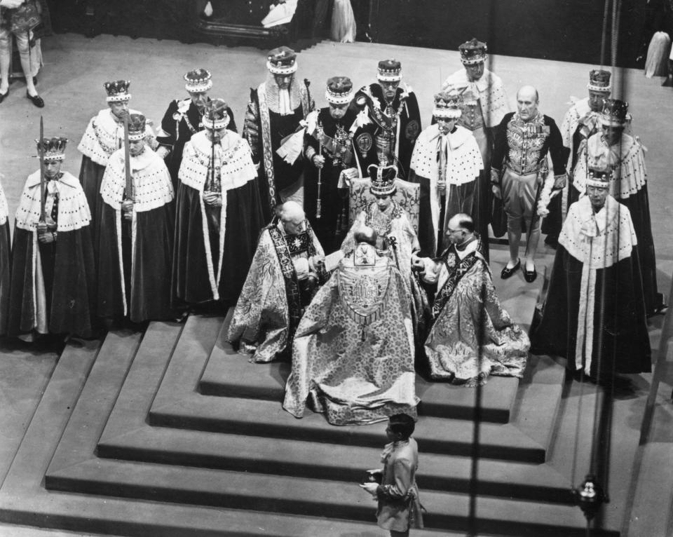 Queen Elizabeth sits in a throne during her coronation at Westminster Abbey.