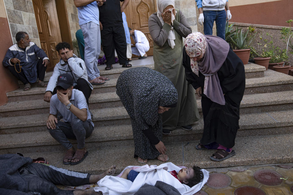 Palestinos llorando a familiares muertos en bombardeos israelíes en la Franja de Gaza, en una morgue en Khan Younis, el martes 17 de octubre de 2023. (AP Foto/Fatima Shbair)