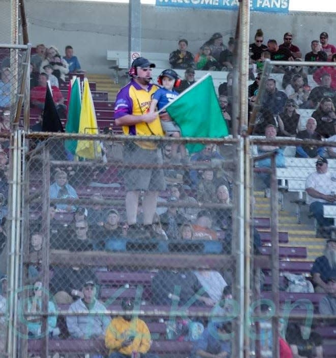 Adam Sternard mans the flagstand with his son Brock at The Hill Raceway at the Door County Fairgrounds in Sturgeon Bay. Sternard and his cousin, John Sternard, formed Sternard Motorsports LLC and will promote stock car racing at the track in 2024.
