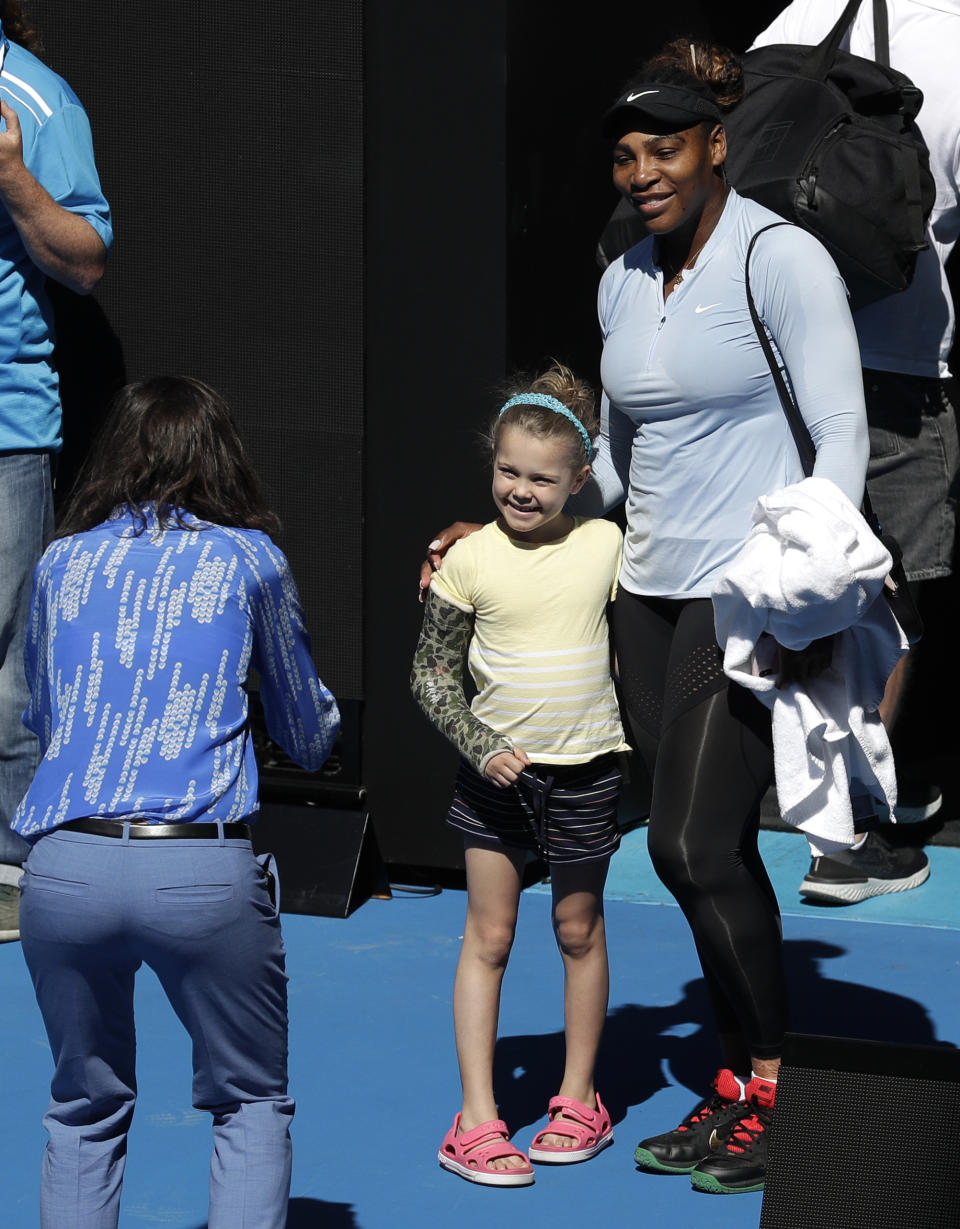 United States' Serena Williams poses for. Photo with a young fan following a practice session at the Australian Open tennis championships in Melbourne, Australia, Sunday, Jan. 13, 2019. (AP Photo/Kin Cheung)