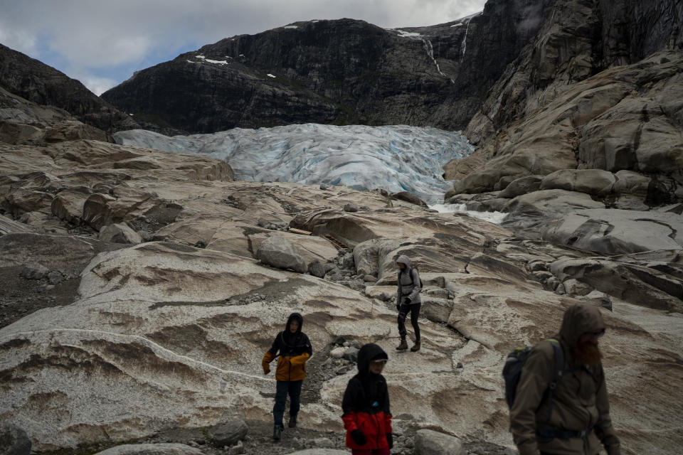 Tourists hike to visit the Nigardsbreen glacier in Jostedal, Norway, on Aug. 5, 2022. The Nigardsbreen glacier has lost almost 3 kilometers (1.8 miles) in length in the past century due to climate change. (AP Photo/Bram Janssen)
