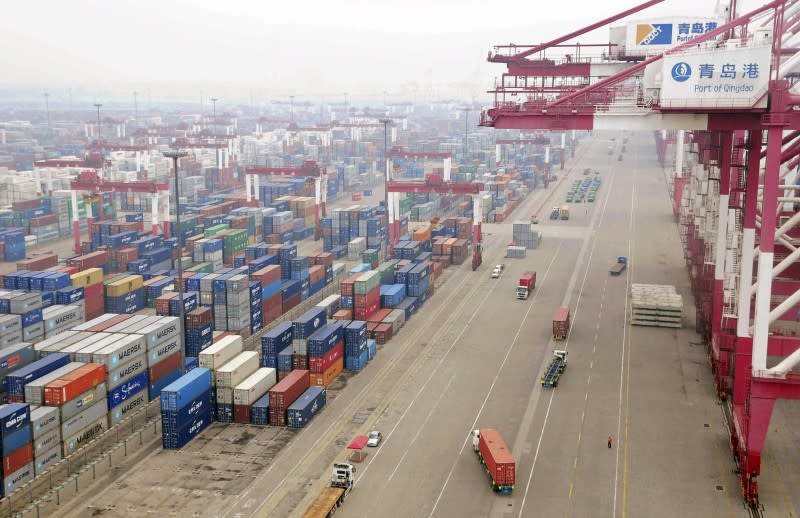 FILE PHOTO: Trucks are used to transport containers at a port in Qingdao, Shandong province July 10, 2013. REUTERS/China Daily