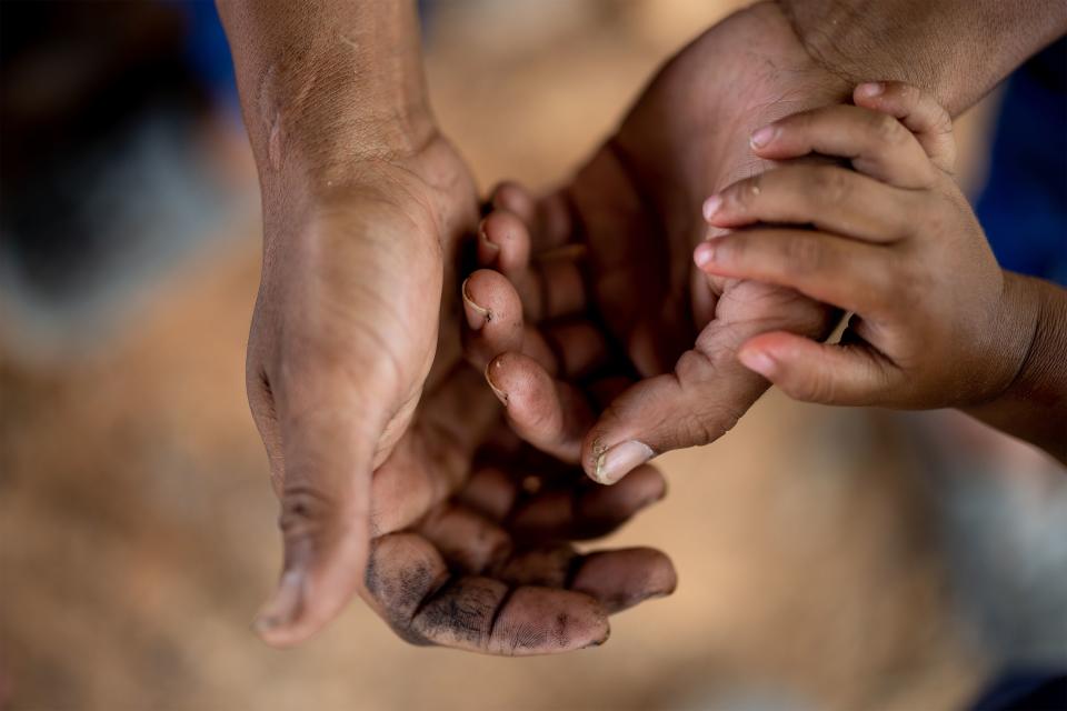 Venezuelan migrant Yorman Jesus Mendoza Miers and his son, Thiago Jesus Mendoza Rodriguez, 3, sit together in a migrant camp in Necoclí. | Spenser Heaps, Deseret News