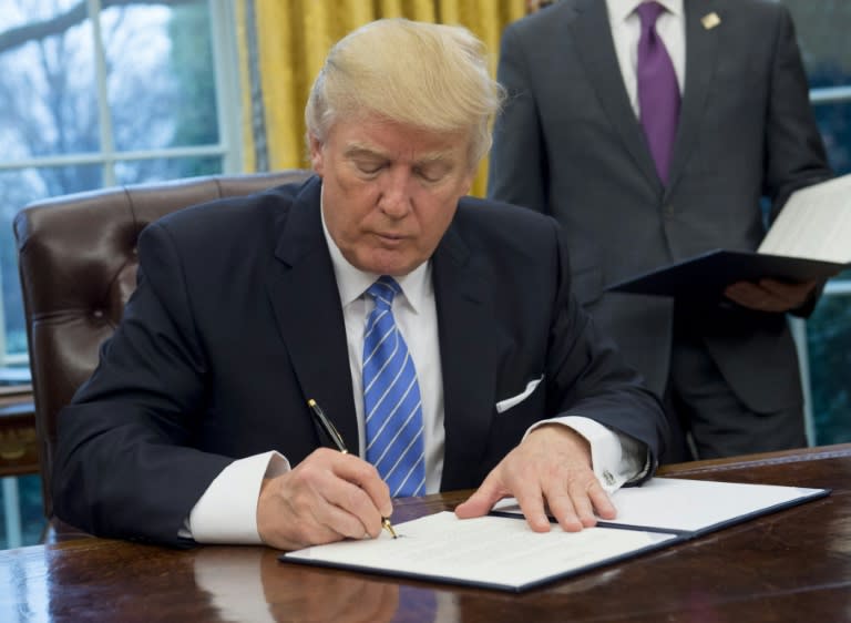 US President Donald Trump signs an executive order withdrawing the US from the Trans-Pacific Partnership in the Oval Office of the White House on January 23, 2017