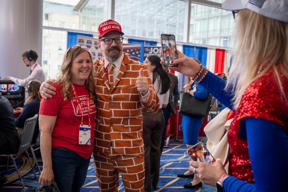 Blake Marnell, of San Diego, center, dressed in his “wall suit,” poses for a photo with other another attendee of the Conservative Political Action Conference, CPAC 2024, at National Harbor in Oxon Hill, MD (AP)