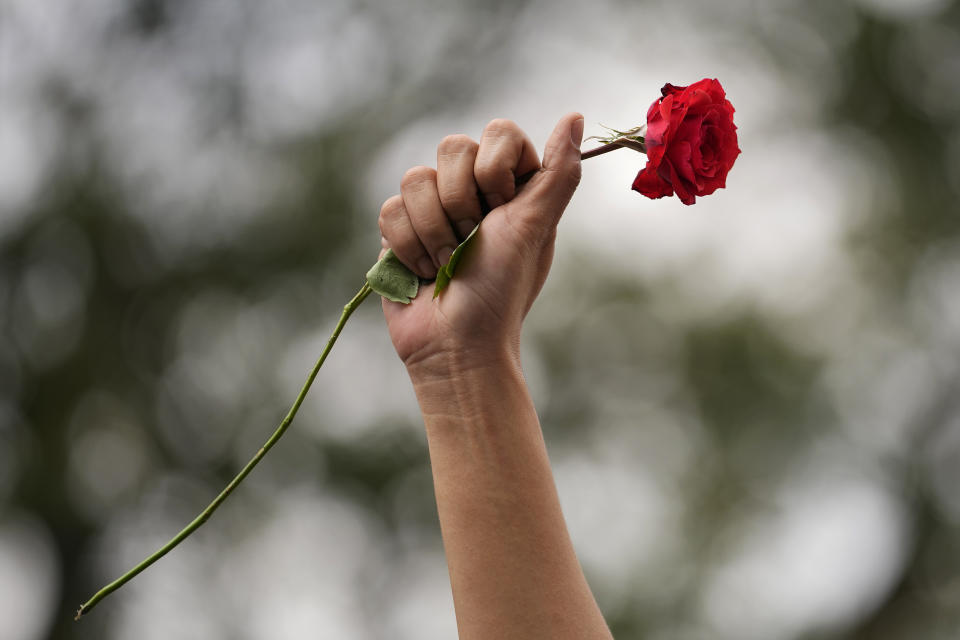 Una manifestante levanta el puño al aire con una rosa roja durante una protesta con motivo del Día Internacional de la Mujer, el 8 de marzo de 2023, en Manila, Filipinas. (AP Foto/Aaron Favila)