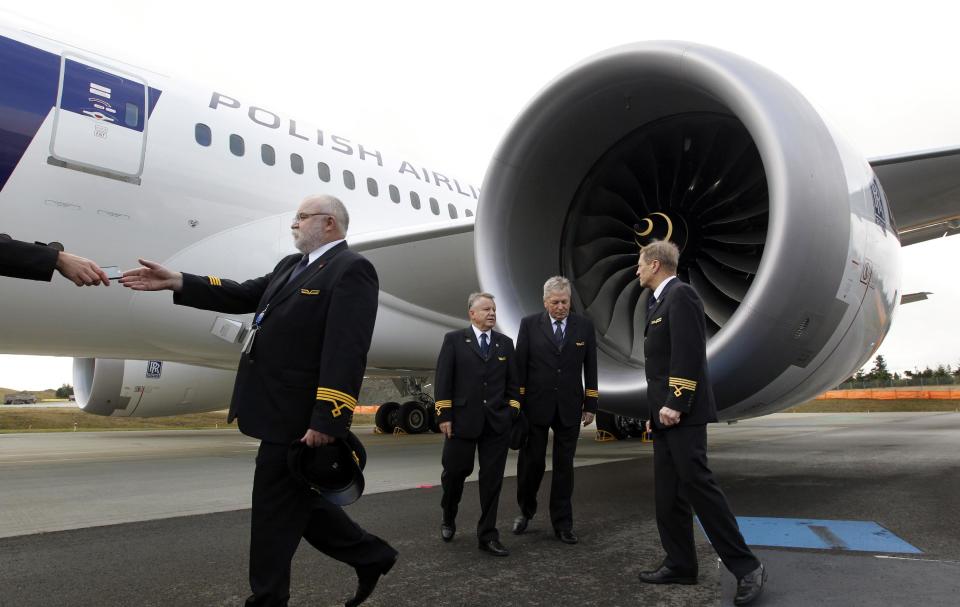 LOT Polish Airlines pilots stand near one of the engines after posing for photos in front of a Boeing 787 during a delivery ceremony Wednesday, Nov. 14, 2012, at Paine Field in Everett, Wash. LOT Polish Airlines took delivery of its first Boeing 787 and plans to fly early next year on routes between Poland and New York, Chicago and Toronto. Poland's LOT was Europe's first airline to purchase the new plane with an order for eight. Boeing says the 787 is the first mid-size plane capable of flying long-range routes, allowing airlines to open new, non-stop flights. (AP Photo/Elaine Thompson)