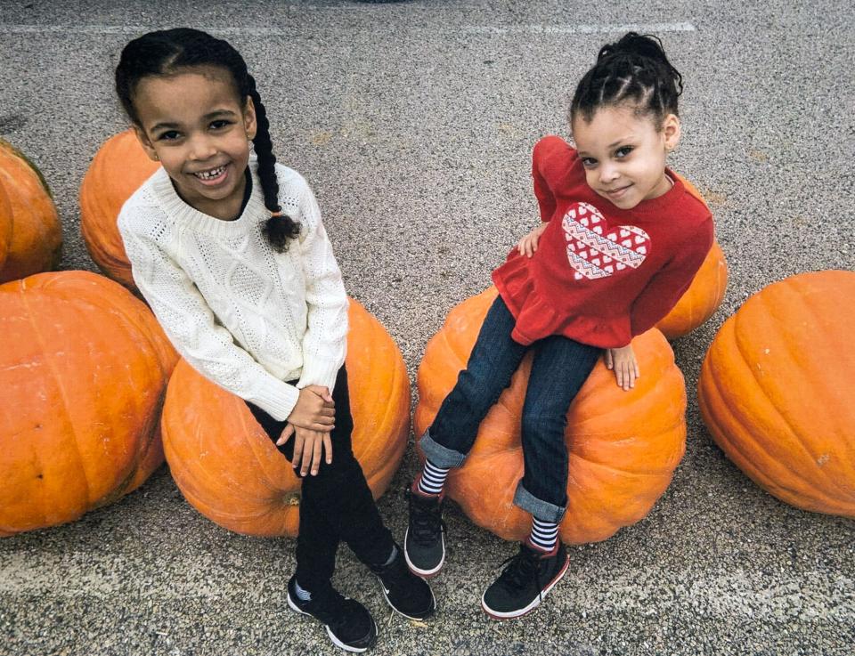 Sisters Giana, left, and Aaminah Vicosa sit on pumpkins in a submitted portrait.