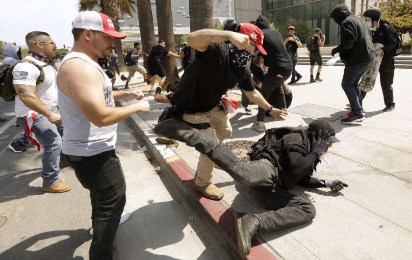 LOS ANGELES, CA - AUGUST 14, 2021 - - Advocates against vaccine mandates confront pro-vaccine advocates in front of the L.A.P.D. Headquarters in downtown Los Angeles on August 14, 2021. One man was stabbed during the melee and was taken by paramedics to a nearby hospital. (Genaro Molina / Los Angeles Times)