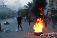Protesters burn tires in the street during a demonstration in Baghdad, Iraq, Tuesday, Oct. 1, 2019. Iraqi security forces fired rubber bullets and tear gas in Baghdad Tuesday on protesters demonstrating against corruption and poor public services injuring more than a dozen people, medical official said. (AP Photo/Hadi Mizban)