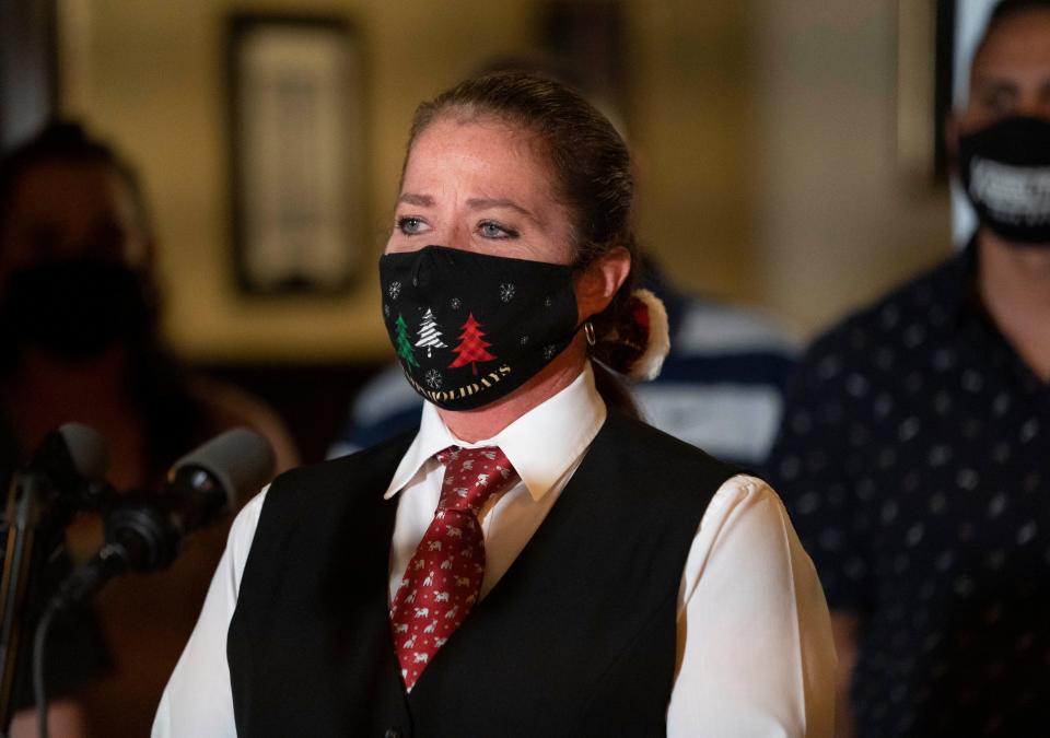 Waitress Theresa Hodgdon listens to Florida Governor Ron DeSantis during a press conference at the Okeechobee Steakhouse on December 15, 2020 in West  Palm Beach, Florida. DeSantis talked about the importance of keeping restaurants open during the pandemic  to help employees earn a living. (GREG LOVETT/THE PALM BEACH POST)