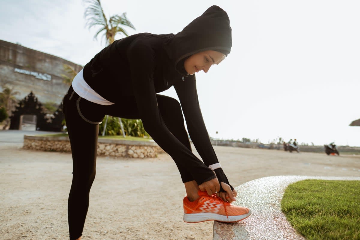 Young muslim woman tying shoelace