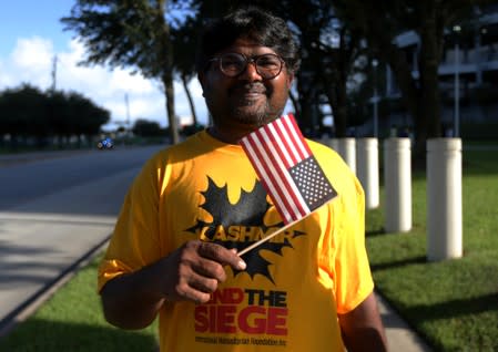 A counter-demonstrator, who did not give a name, poses for a photograph during a "Howdy, Modi" rally celebrating India's Prime Minister Narenda Modi at NRG Stadium in Houston