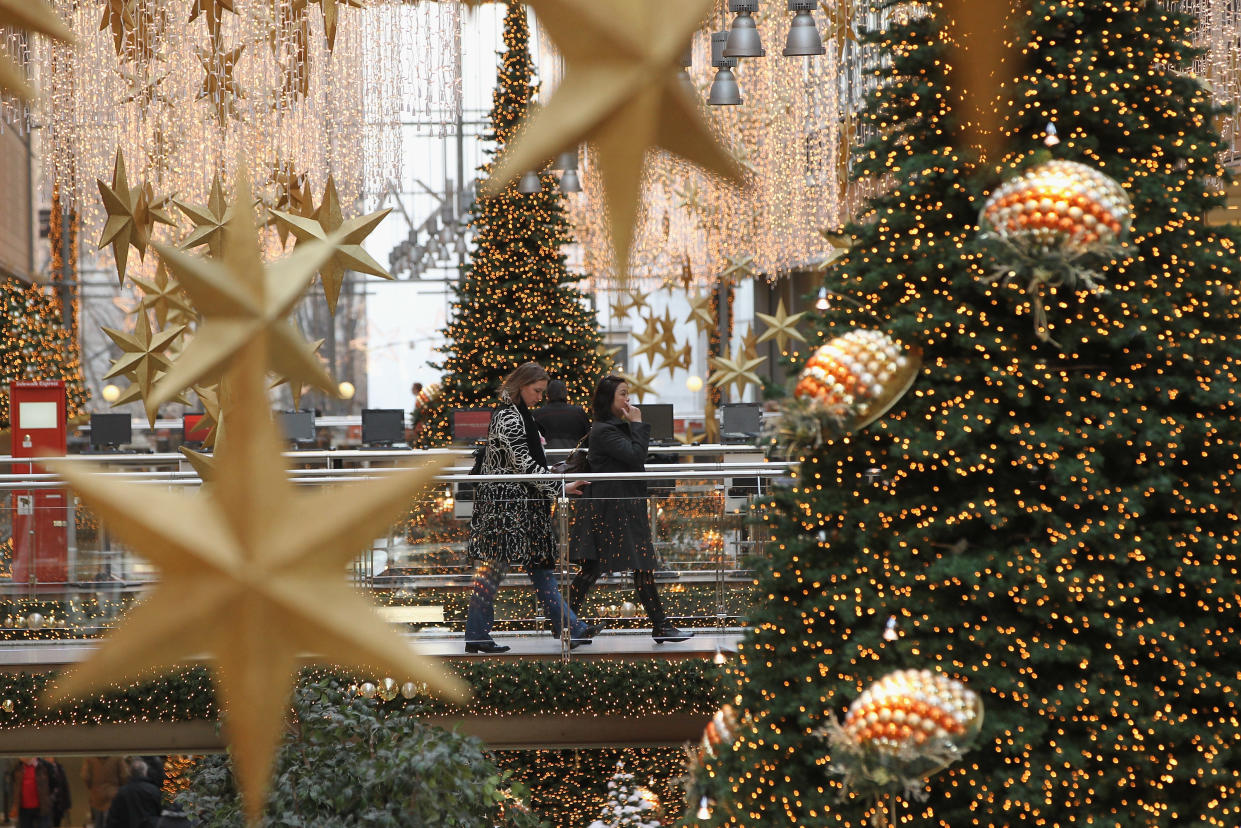 People walk among Christmas trees and decorations in the Potsdamer Platz Arkaden shopping mall on November 30, 2011 in Berlin, Germany. (Photo by Sean Gallup/Getty Images)