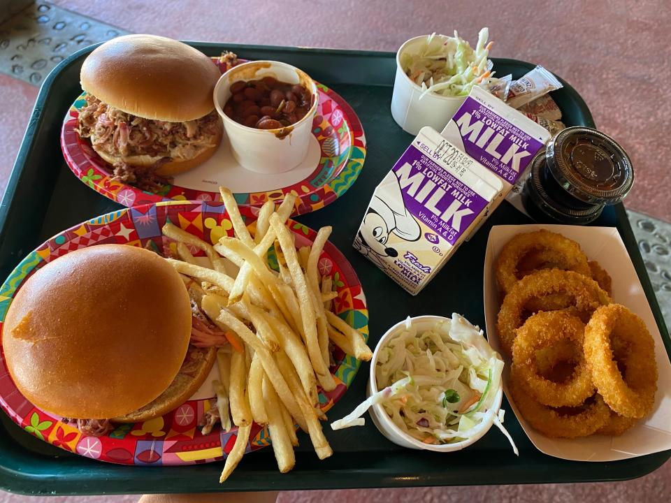 cafeteria tray of pulled pork sandwiches, onion rings, and drinks from disney animal kingdom