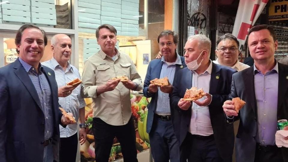 巴西總統府祕書長拉莫斯、巴西觀光部長馬查多紛紛在社群軟體上發布與巴西總統波索納洛（左起第三）一起在路邊吃披薩、喝可樂的照片。（擷取自IG/gilsonmachadoneto）