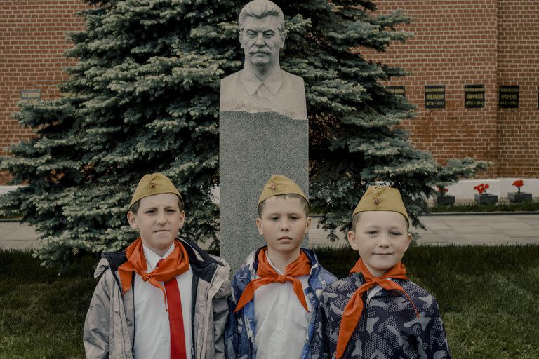 Unos niños posan frente a un busto de Stalin cerca de la Plaza Roja de Moscú, el 21 de mayo de 2023. El Presidente Vladimir Putin ha rehabilitado en gran medida a Stalin, a pesar de su gulag, ya que el hilo con el pasado sigue intacto. 