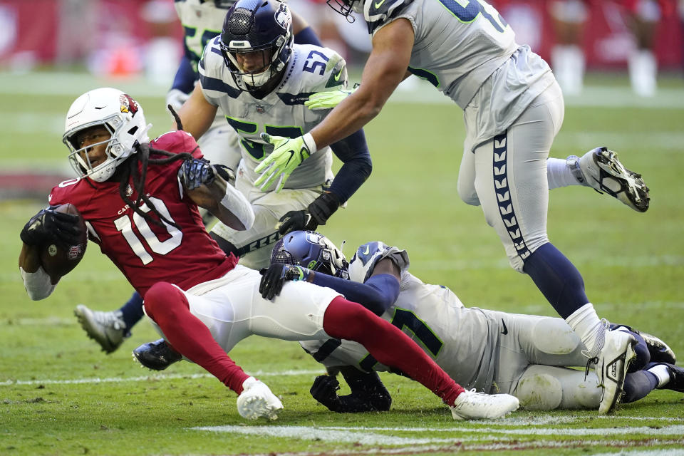 Arizona Cardinals wide receiver DeAndre Hopkins (10) is tackled by Seattle Seahawks cornerback Tariq Woolen, bottom, during the first half of an NFL football game in Glendale, Ariz., Sunday, Nov. 6, 2022. (AP Photo/Ross D. Franklin)