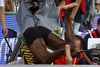 Usain Bolt of Jamaica collides with a cameraman on a segway after the men's 200m final during the 15th IAAF World Championships at the National Stadium in Beijing, China August 27, 2015. REUTERS/Lucy Nicholson