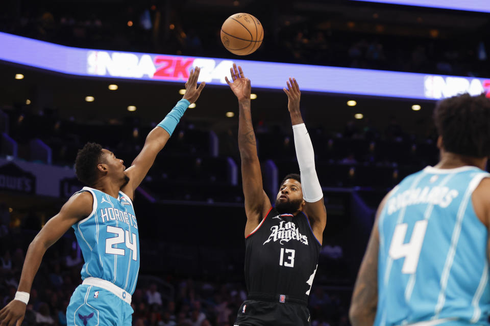 Los Angeles Clippers forward Paul George (13) shoots over Charlotte Hornets forward Brandon Miller (24) during the first half of an NBA basketball game in Charlotte, N.C., Sunday, March 31, 2024. (AP Photo/Nell Redmond)