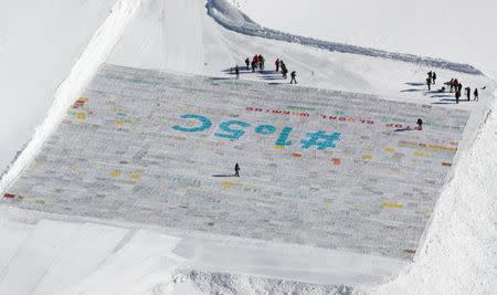 Media stands next to 100,000 postcards with messages against climate change, sent by young people from all over the world and stuck together to break the Guinness World Record of the biggest postcard, on the Jungfraufirn, the upper part of Europe's longest glacier, the Aletschgletscher, near Jungfraujoch, Switzerland November 16, 2018. REUTERS/Arnd Wiegmann