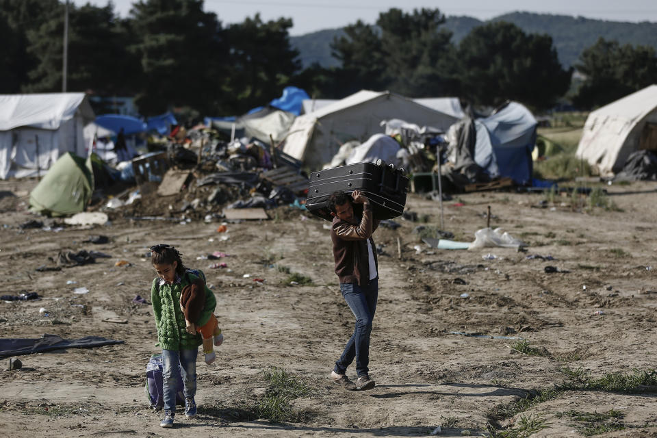 <p>Migrants carry their belongings as they leave a makeshift camp during a police operation at the Greek-Macedonian border near the northern Greek village of Idomeni, May 26, 2016. Greek police continue to evacuate the sprawling, makeshift Idomeni refugee camp where more than an estimated 8,400 people have been living for months. (Yannis Kolesidis/AP) </p>