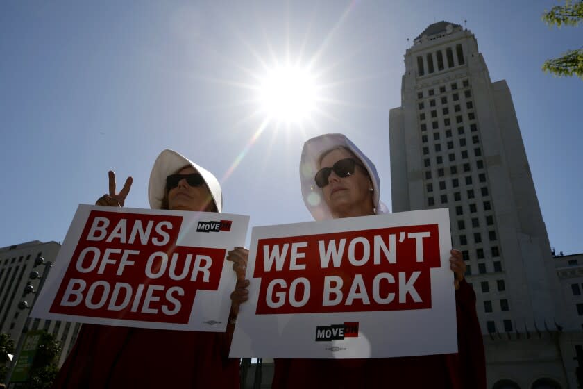 LOS ANGELES CA MAY 14, 2022--(From L-R), Laureen Sills and Dianette Wells, both from Malibu hold up a sign before the start of the women's abortion rights rally in downtown Los Angeles Saturday, May 14, 2022.