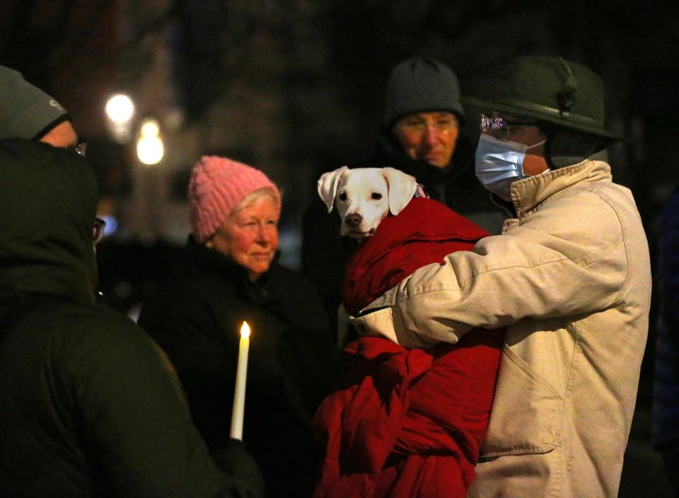 Cross Roads House Executive Director Will Arvelo holds his dog, Piper, during the Homeless Persons' Memorial Day vigil in Portsmouth Thursday, Dec. 21, 2023.