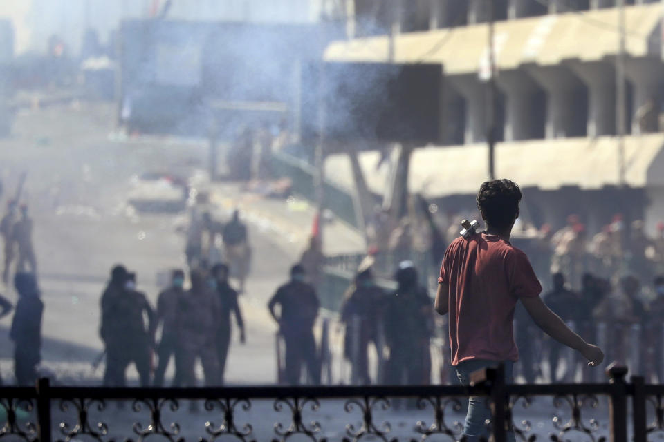 Iraqi riot police fire tear gas to disperse anti-government protesters gathering on bridge in central Baghdad, Iraq, Saturday, Nov. 9, 2019. (AP Photo/Hadi Mizban)