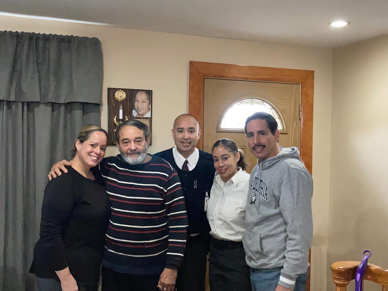The Villegas family--Belinda Villegas-Ramos, Carmelo Villegas Sr., Carmelo Jr., Romelia Villegas-Diaz and Woody (left to right)--stand in front of a photo of their late matriarch Maria at Belinda's Camden home.