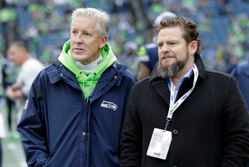 In this Dec. 30, 2018, file photo, Seattle Seahawks coach Pete Carroll, left, talks with general manager John Schneider before  the team's NFL football game against the Arizona Cardinals in Seattle. There is a clear and obvious need for the Seahawks to address along the defensive line and it happens to be one of the deeper positions of talent in the entire draft. That may be far too simplistic and straightforward for Schneider and Carroll. Schneider is always good for a few surprises in the draft, and more than a couple of trades.