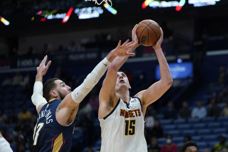 Denver Nuggets center Nikola Jokic (15) goes to the basket against New Orleans Pelicans center Jonas Valanciunas (17) in the first half of an NBA basketball game in New Orleans, Wednesday, Dec. 8, 2021. (AP Photo/Gerald Herbert)
