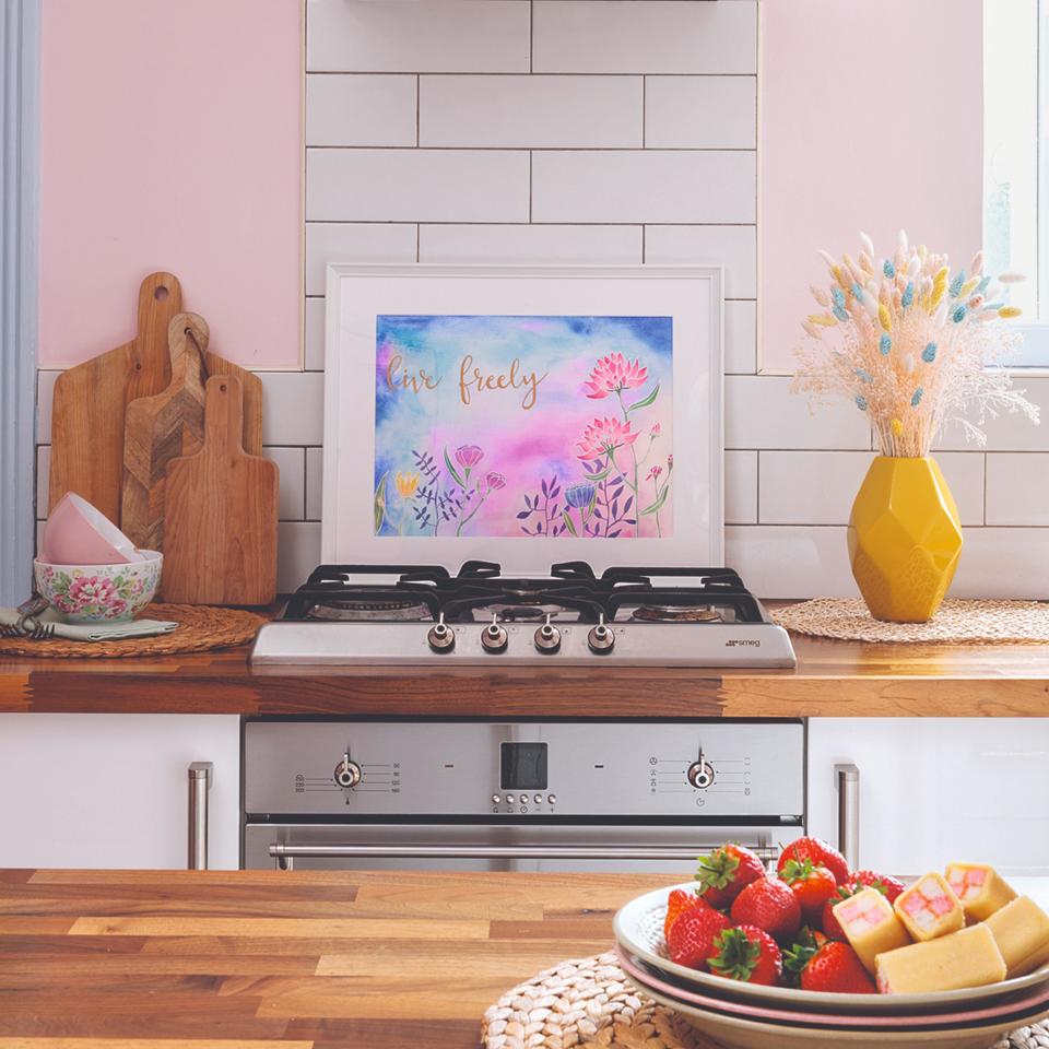 Kitchen with pink walls, wooden counter tops and a bowl of strawberries