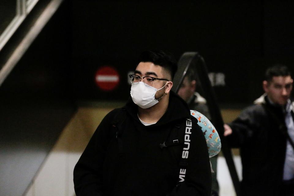 FILE PHOTO: A traveler wearing a mask arrives on a direct flight from China, after a spokesman from the U.S. Centers for Disease Control and Prevention (CDC) said a traveler from China had been the first person in the United States to be diagnosed with the Wuhan coronavirus, at Seattle-Tacoma International Airport in Washington, U.S. January 23, 2020.  REUTERS/David Ryder/File Photo