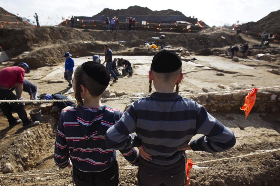Ultra-Orthodox Jewish boys look at an excavation site where a mosaic floor of an ancient Byzantine church was uncovered near Kiryat Gat