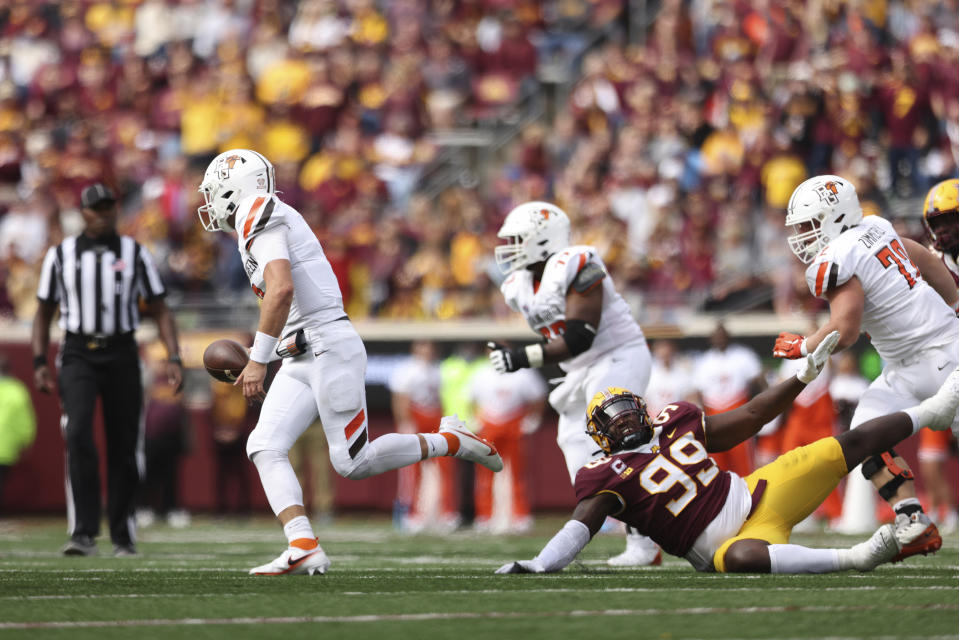 Bowling Green quarterback Matt McDonald (3) runs with the ball after avoiding a tackle by Minnesota defensive lineman DeAngelo Carter (99) during the second half of an NCAA college football game Saturday, Sept. 25, 2021, in Minneapolis. Bowling Green won 14-10. (AP Photo/Stacy Bengs)