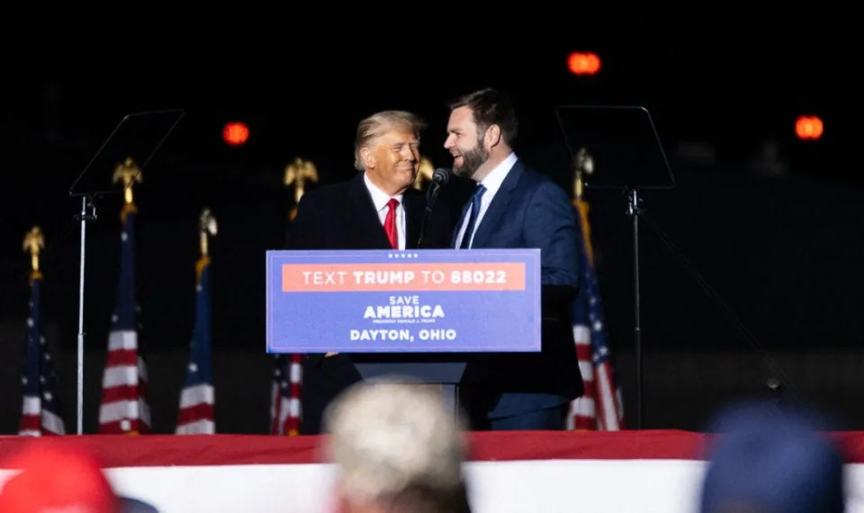 Trump and Vance smile together at podium.