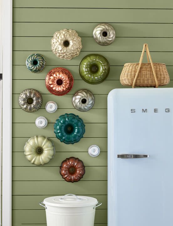 <p>A collection of colorful vintage Bundt pans in assorted shapes lends retro flair to a kitchen or pantry wall. Bonus: You can take ’em down and use them as needed. For another take on this graphic idea, try it with a tray or plate collection.</p>