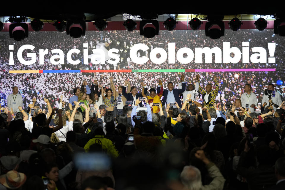 Presidential candidate Gustavo Petro, center, and his running mate Francia Marquez, to his right, with the Historical Pact coalition, stand with their families in front of supporters on election night in Bogota, Colombia, Sunday, May 29, 2022. Petro will advance to a runoff contest in June after none of the six candidates in Sunday's first round got half the vote. (AP Photo/Fernando Vergara)