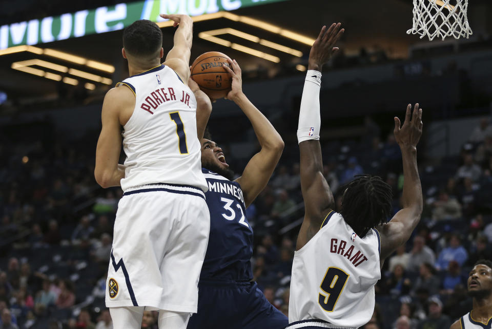 Minnesota Timberwolves' Karl-Anthony Towns shoots the ball against Denver Nuggets' Michael Porter Jr. and Jerami Grant in the first half of an NBA basketball game Monday, Jan. 20, 2020, in Minneapolis. (AP Photo/Stacy Bengs)