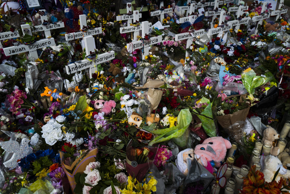 Flowers, stuffed animals and candles are piled around a memorial at Robb Elementary School in Uvalde, Texas Monday, May 30, 2022, to honor the victims killed in last week's school shooting. (AP Photo/Jae C. Hong)