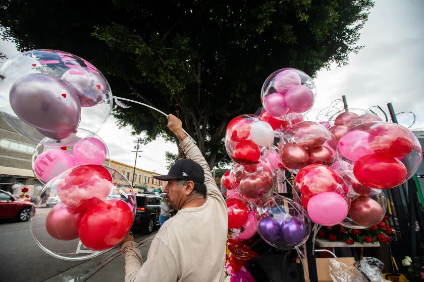 Los Angeles, CA - February 14: Freddy Carrillo is helping sell balloons and flowers on Valentine's Day near the corner of 7th street and San Pedro on Tuesday, Feb. 14, 2023, in Los Angeles, CA. Many merchants are busy selling flowers in shops and on the sidewalk here today. (Francine Orr / Los Angeles Times)