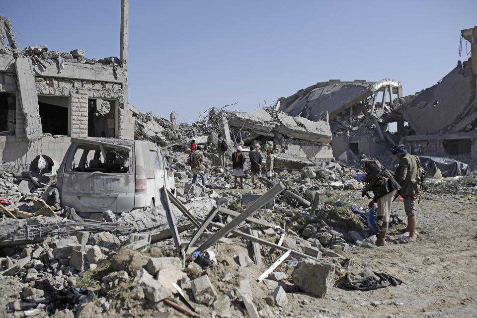 People inspect the rubble at a Houthi detention center destroyed by Saudi-led airstrikes, that killed at least 60 people and wounding several dozen according to officials and the rebels' health ministry, in Dhamar province, southwestern Yemen, Sunday, Sept. 1, 2019. The officials said the airstrikes took place Sunday and targeted a college in the city of Dhamar, which the Houthi rebels use as a detention center. The Saudi-led coalition said it had hit a Houthi military facility used as storages for drones and missiles in Dhamar. (AP Photo/Hani Mohammed)