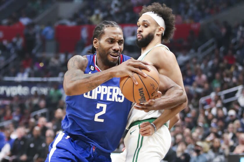 Los Angeles, CA - December 12: LA Clippers forward Kawhi Leonard, left, drives to the basket past Boston Celtics guard Derrick White during the second half at Crypto.com Arena on Monday, Dec. 12, 2022 in Los Angeles, CA.(Allen J. Schaben / Los Angeles Times)