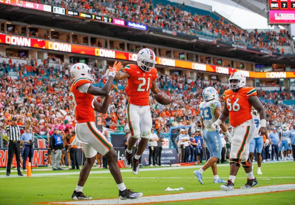 Miami Hurricanes running back Henry Parrish Jr. (21) celebrate with teammates after scoring a touchdown during the second quarter of an ACC conference football game against North Carolina Tar Heels at Hard Rock Stadium on Saturday, October 8, 2022 in Miami Gardens, Florida..