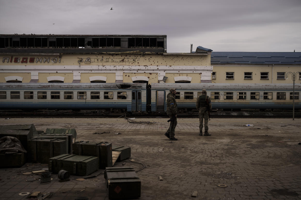 Ukrainian servicemen walk at a damaged train station in the town of Trostsyanets, Ukraine, Monday, March 28, 2022. Trostsyanets was recently retaken by Ukrainian forces after being held by Russians since the early days of the war. (AP Photo/Felipe Dana)