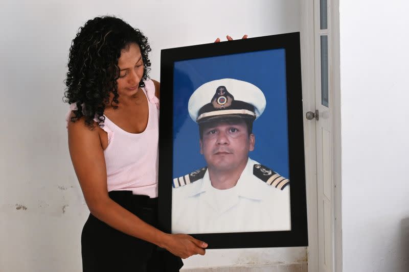 Claudia Patricia Fortich, widow of late oil tanker captain Jaime Herrera Orozco who was murdered on his ship while anchored off Venezuela, holds a picture of her husband at her home, in Cartagena