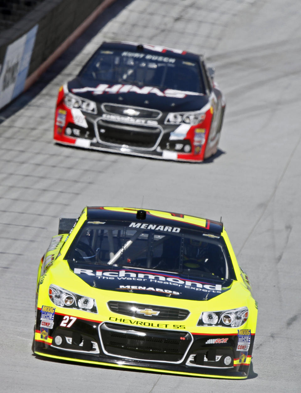 Driver Paul Menard (27) leads Kurt Busch (41) during practice for the NASCAR Sprint Cup series auto race at Bristol Motor Speedway on Friday, March 14, 2014, in Bristol, Tenn. (AP Photo/Wade Payne)